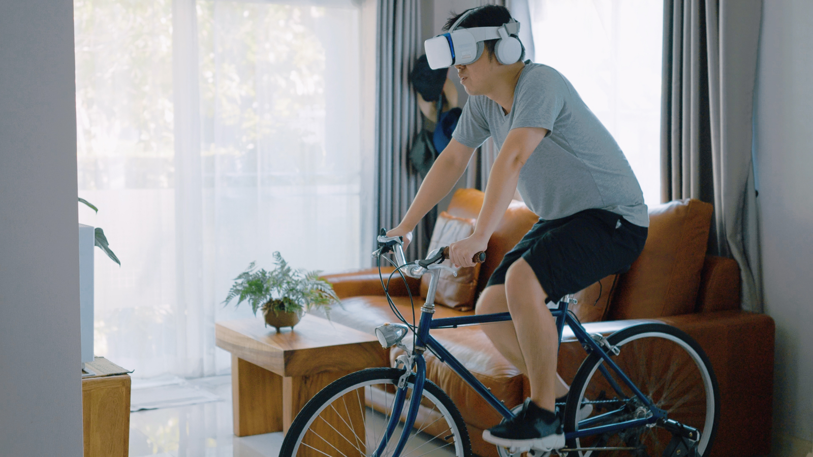 Person riding bike inside with virtual reality goggles