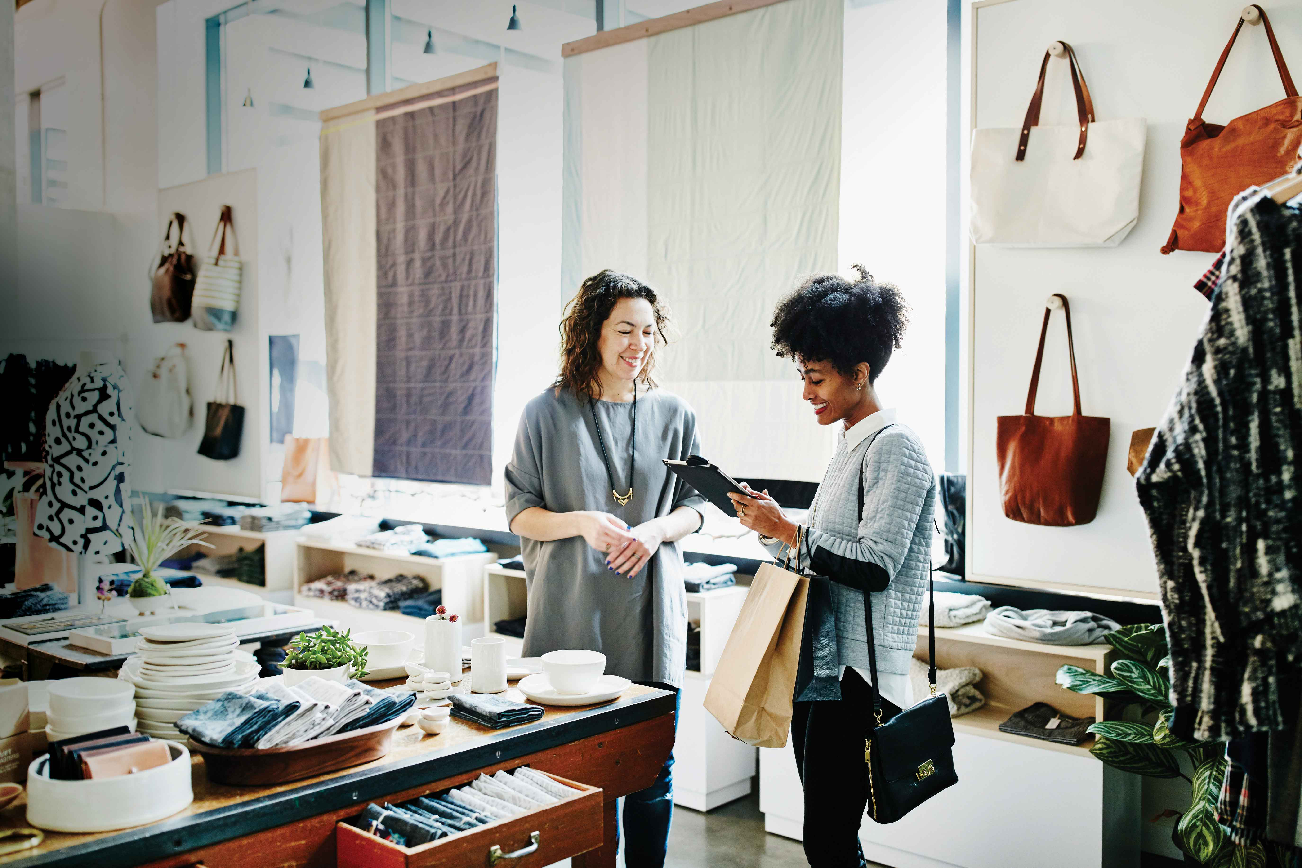 Picture that shows woman in a store looking at an iPad next to a female associate